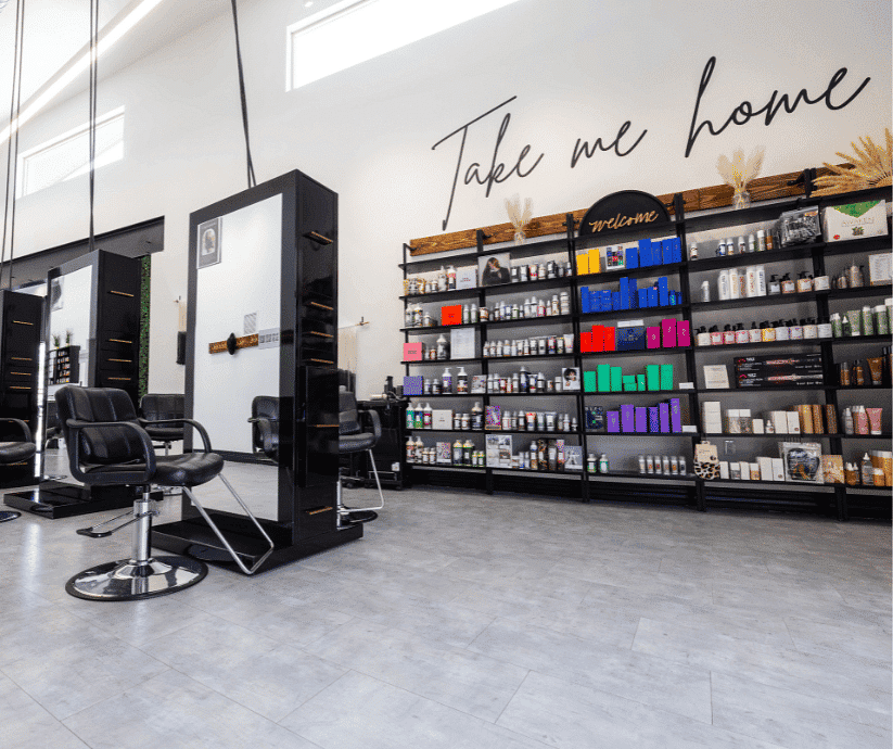 Modern hair salon with styling chairs, mirrors, and shelves stocked with beauty products.