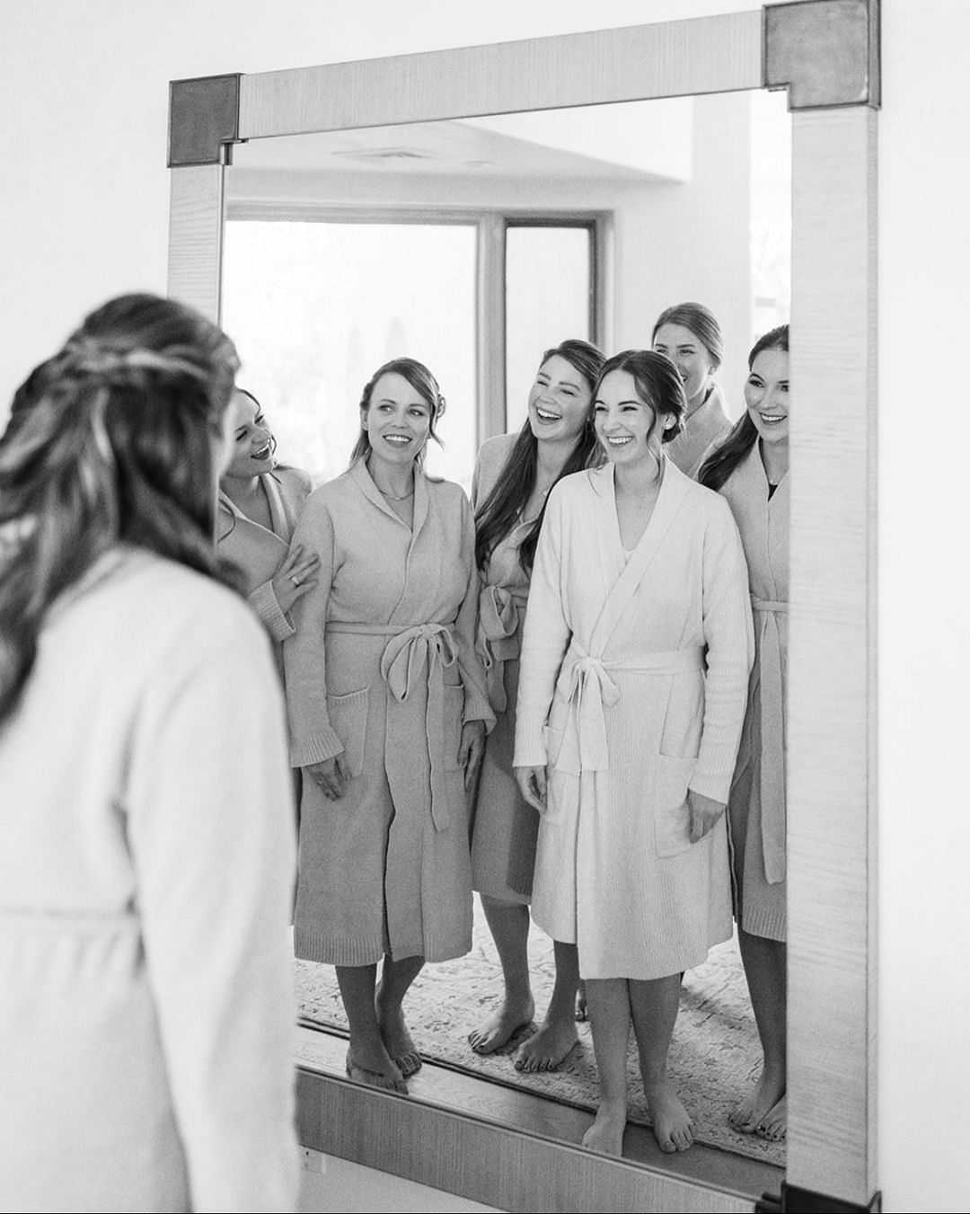 Bridesmaids gathered around a mirror